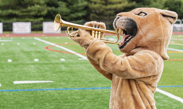 A cougar custom made mascot pretending to play a trumpe